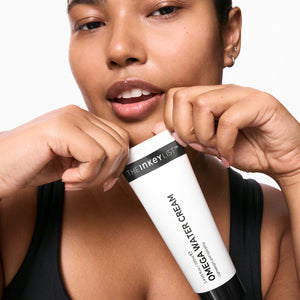 Model holding a tube of Omega Water Cream 100ml