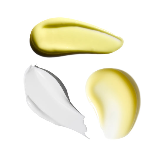 Three swatches of different colored creams on a white background