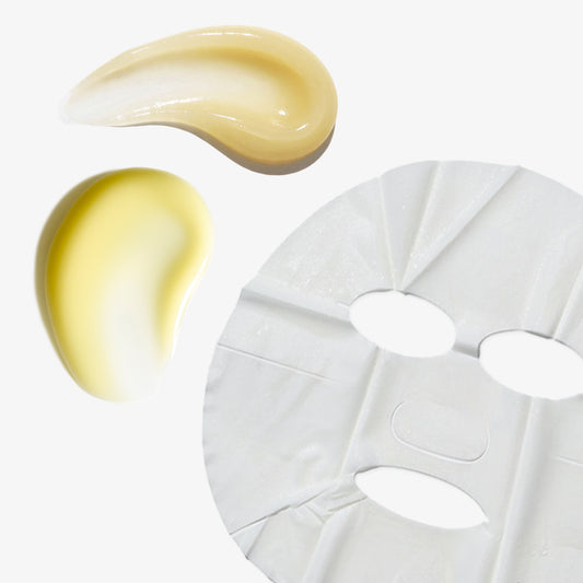 A white sheet mask with cutouts for eyes, nose, and mouth, shown next to two glossy droplets of pale yellow skincare serum on a clean white background.
