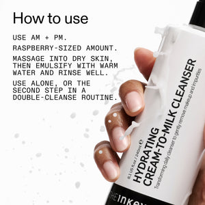 Hand holding a skincare product with Milk Cleanser usage instructions on a white background