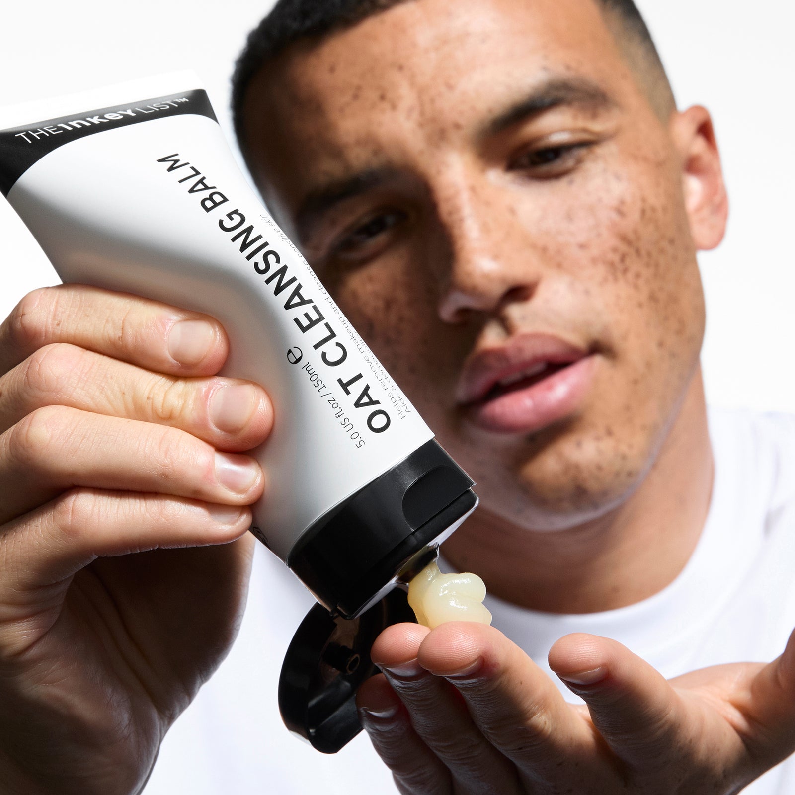 Model squeezing Oat Cleansing Balm into his fingers