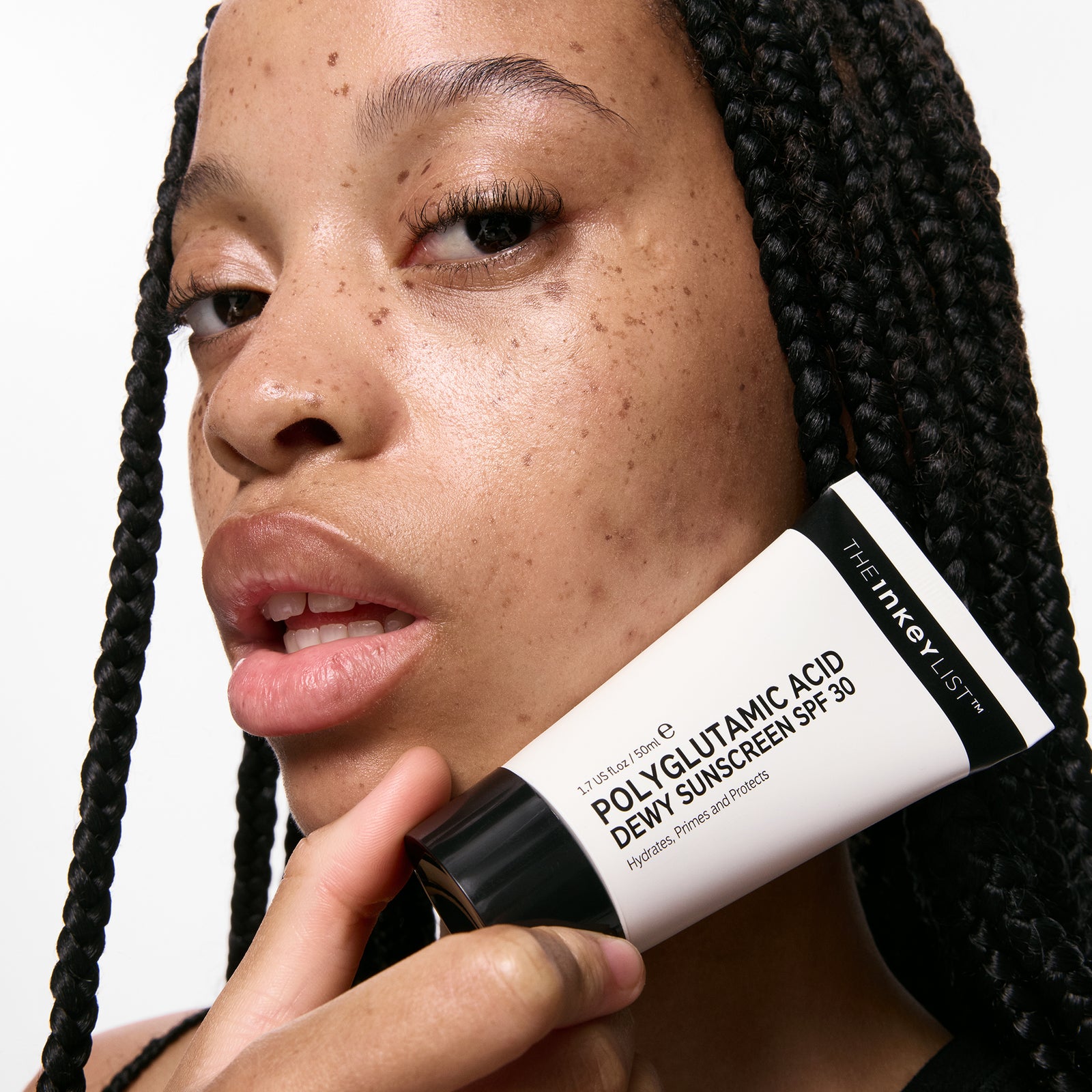 Person holding a tube of The Inkey List Polyglutamic Acid Dewy Sunscreen SPF 30.
