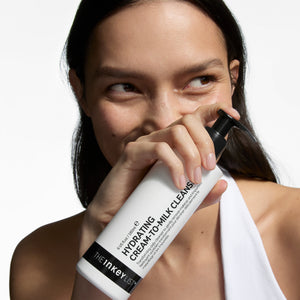 Woman holding aMilk Cleanser with a white background