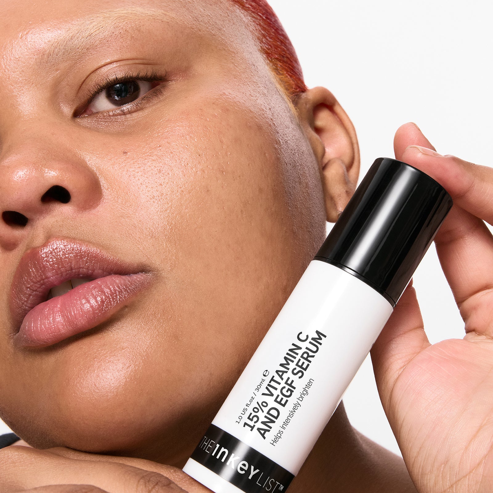 Person holding 15% Vitamin C + EGF Serum with a neutral background