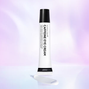Caffeine Eye Cream product against purple background with some cream at the base of the tube