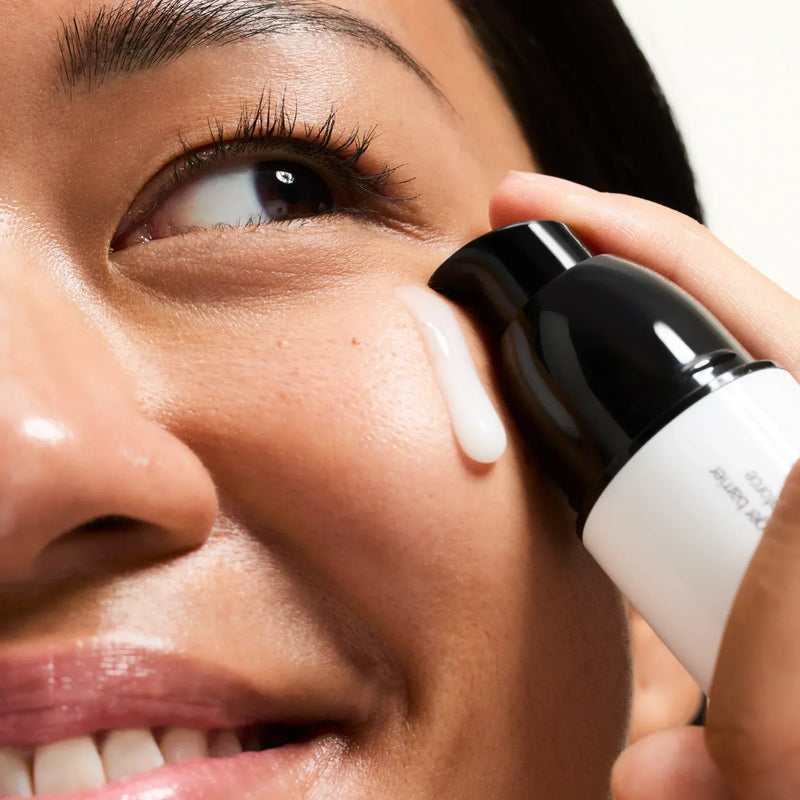 woman putting serum on her face