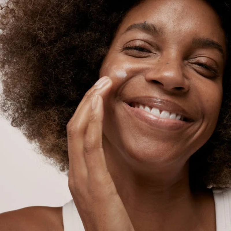 woman applying cream to her face