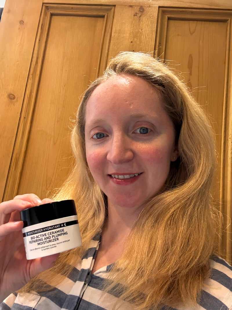 A woman holding a bottle of Bio Active Moisturiser to her face 