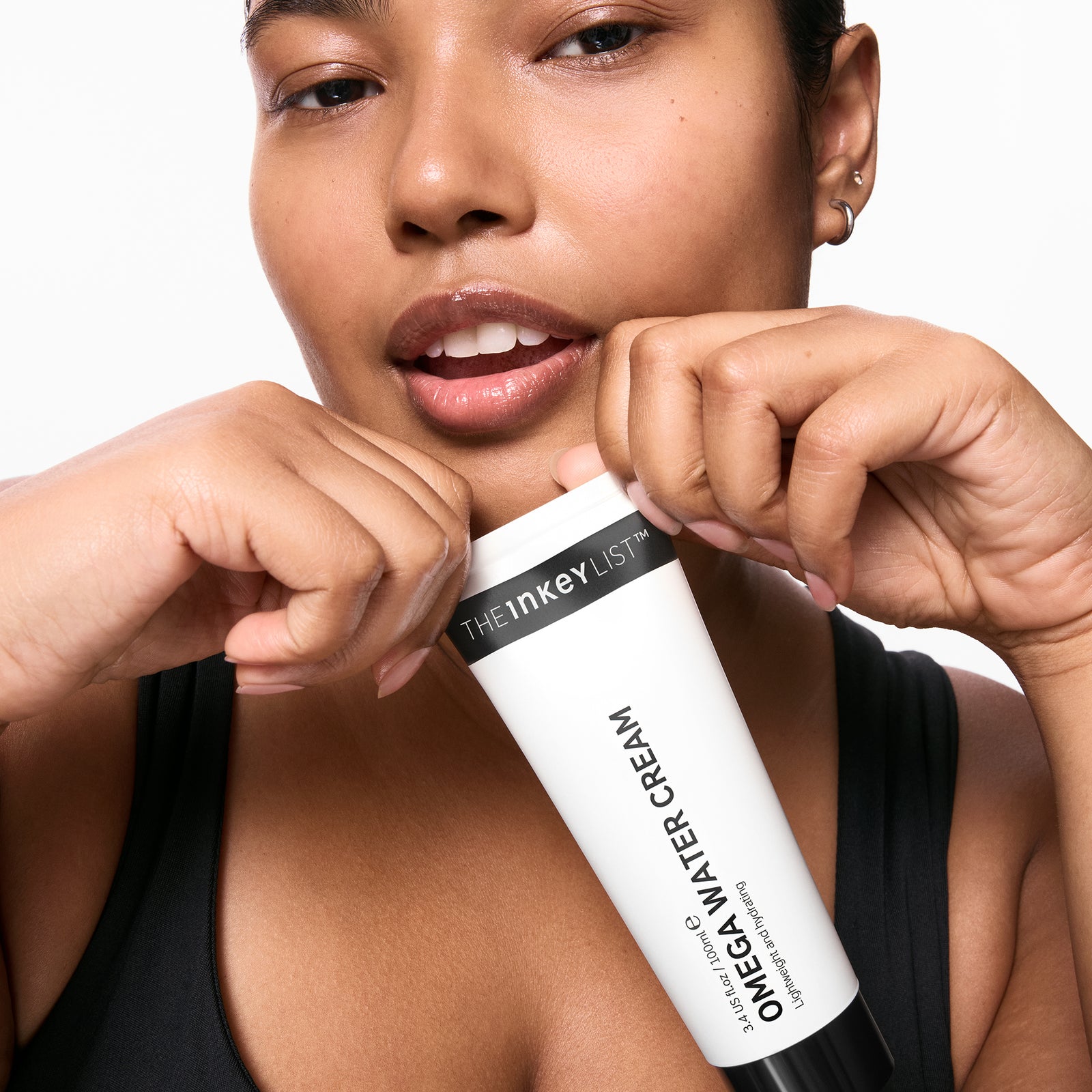 Model holding a tube of Omega Water Cream 100ml