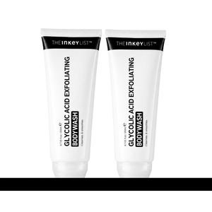 Two white squeeze tubes of THE INKEY LIST Glycolic Acid Exfoliating Body Wash standing side by side on a white background with a thick black horizontal bar at the bottom.