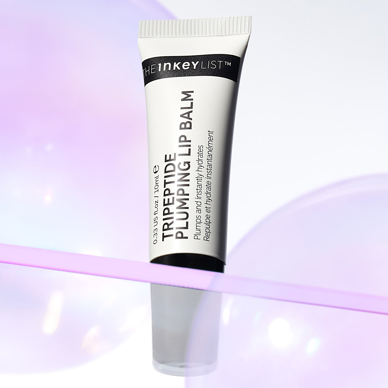 Tripeptide Plumping Lip Balm tube on a purple shelf