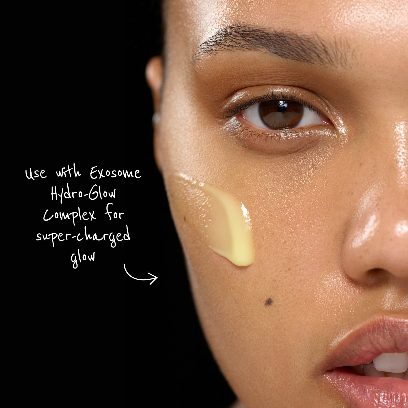 Close-up of a person's face with Exosome Hydro-Glow Complex applied, against a black background.