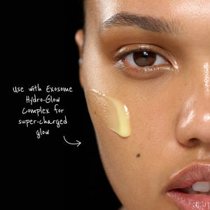 Close-up of a person's face with Exosome Hydro-Glow Complex applied, against a black background.