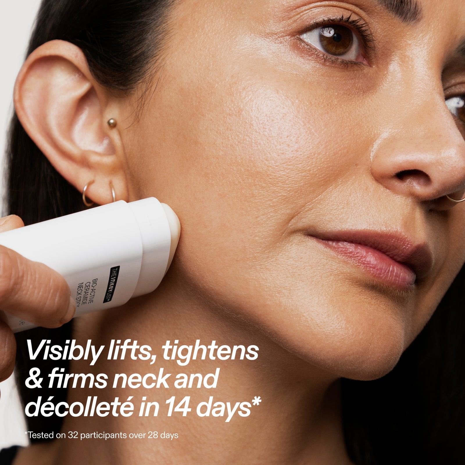 Close-up of a woman's face and neck with a hand holding a white cosmetic device against her jawline. Text on the image reads, 'Visibly lifts, tightens & firms neck and décolleté in 14 days*'.