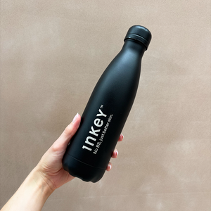 Hand holding the INKEY black chilly bottle
