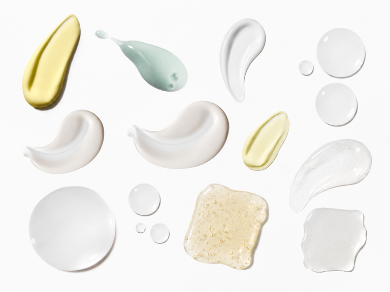 Various textures and colors of cream or lotion on a white background