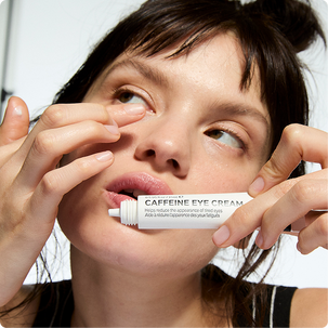 Model applying caffeine eye cream