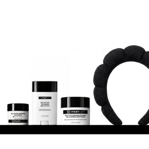 A skincare set from Heiney List on a white background, featuring a black silicone headband on the right, and three black-and-white containers on the left: a jar of Bio Active Ceramide Eye Cream, a stick of Bio-Active Neck Stick, and a jar of Bio-Active Ceramide Moisturizer.