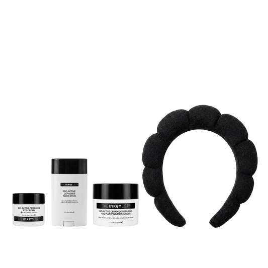 Three INKEY products and a black padded headband arranged on a plain white background. The products include a small jar, a stick container, and a larger jar, all with black lids and white labels, alongside a black fabric headband with a scalloped edge.