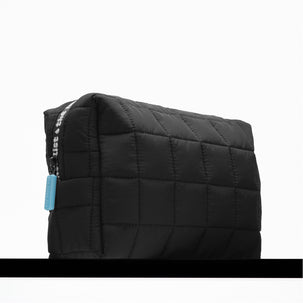 Black quilted bag with a visible brand tag on a white background