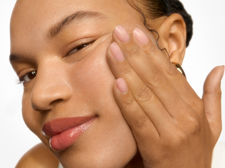 Woman touching her face with a neutral background