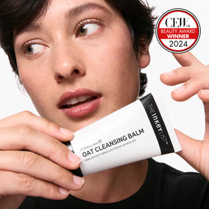 Model holding Oat Cleansing Balm and CEW UK Award in the corner