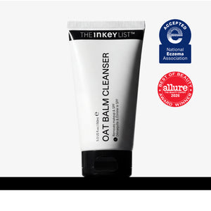 A white tube of The Inkey List Oat Balm Cleanser with a black cap, shown on a light gray background with two award badges on the right: a blue National Eczema Association Accepted badge and a red Allure Best of Beauty 2024 award badge.