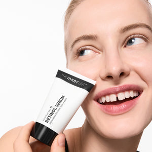 Woman holding Retinol Serum with a plain background