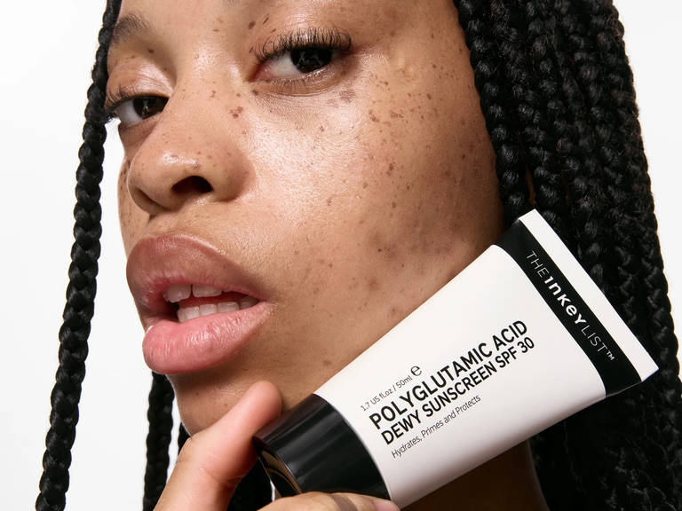Person holding a tube of The Inkey List Polyglutamic Acid Dewy Sunscreen SPF 30.