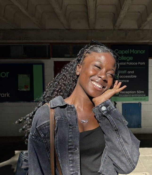 A woman wearing a black jacket with long hair posing for a picture