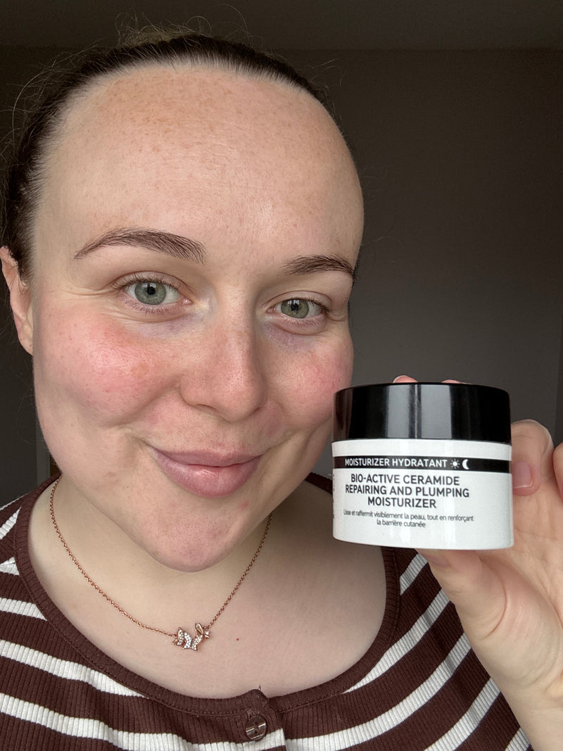 A woman holding a bottle of Bio Active Moisturiser to her face 