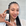 Person holding a skincare product in front of a tiled wall