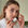 Woman holding a skincare product in a bathroom setting