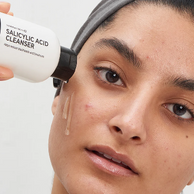 woman applying cleanser to her face