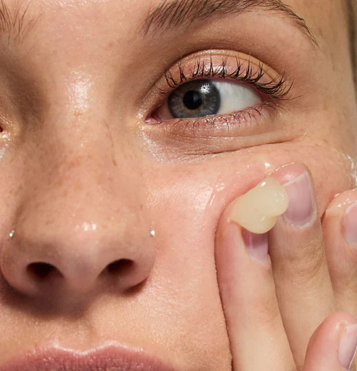 woman applying oat cleansing balm to her face