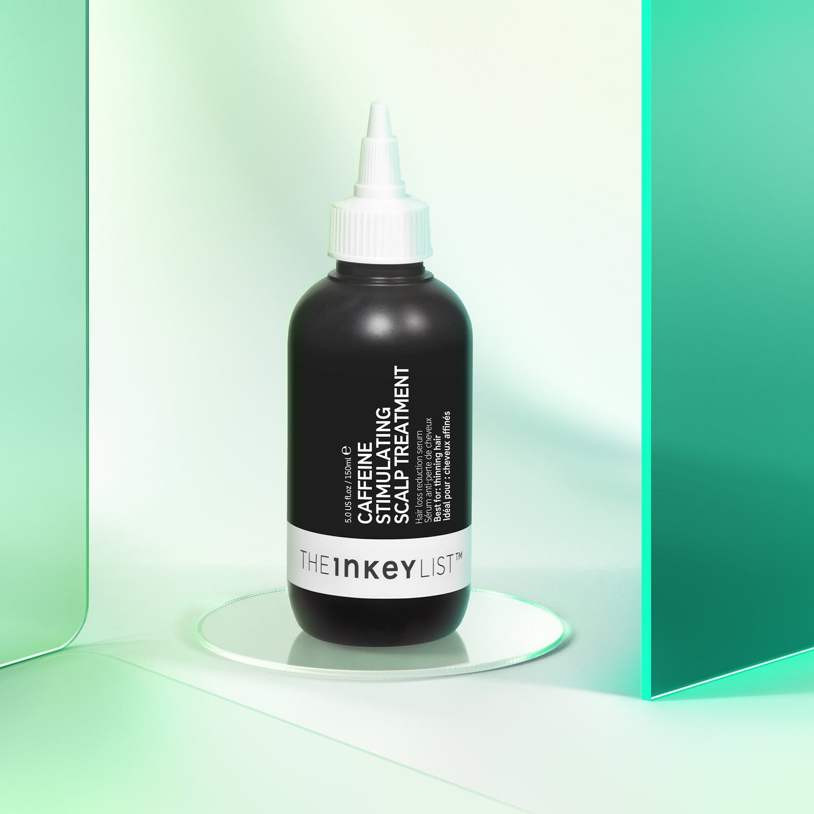 Caffeine stimulating scalp treatment product against a green background