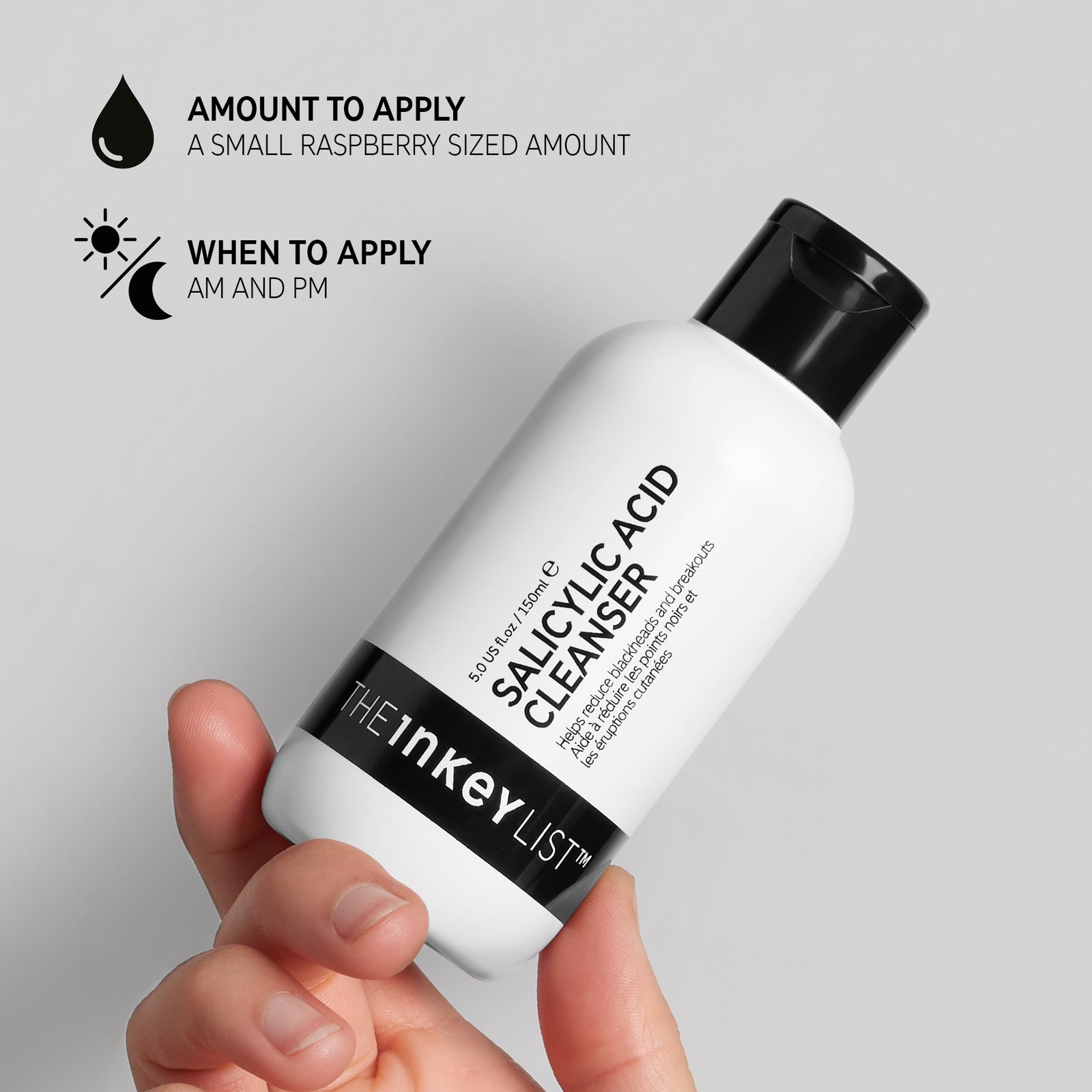 Hand holding Salicylic Acid Cleanser bottle with black text explaining how and when to use it. The text reads 'Amount to apply (small raspberry sized amount)' and 'When to apply (AM and PM)'